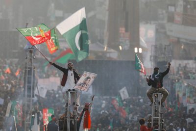 Supporters of the Pakistan's former Prime Minister Imran Khan sit on scaffoldings to see their leader during what they call 'a true freedom march' to pressure the government to announce new elections, Rawalpindi, Pakistan, 26 November 2022 (Photo: Reuters/Akhtar Soomro)