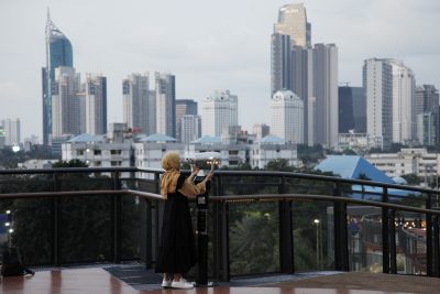 People enjoy Jakarta landscapes from the Senayan Skywalk bridge in Jakarta, Indonesia, 18 April 2022 (Photo: Reuters via NurPhoto/Aditya Irawan).