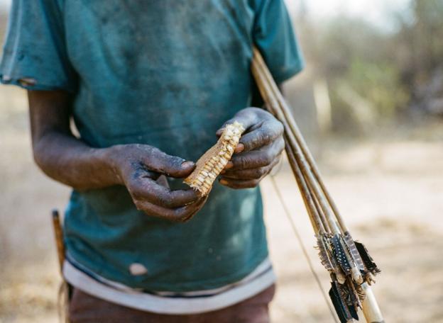 A Hadza man holds a honeycomb