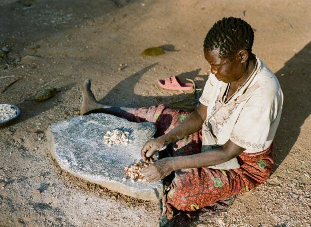 A Hadza woman sits preparing food