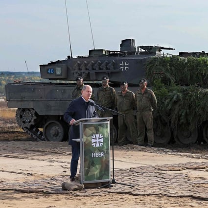 German Chancellor Olaf Scholz speaks next to a Leopard 2 battle tank of the German armed forces while visiting troops at a military ground in Ostenholz, northern Germany, on October 17, 2022. Germany on January 25 approved the delivery of Leopard 2 tanks to Ukraine, after weeks of pressure from Kyiv and many allies. Photo: AFP