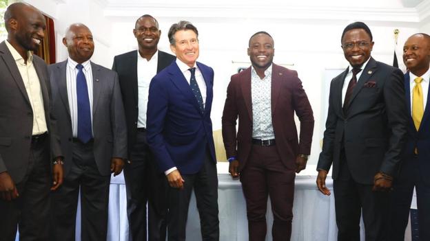 Lord Coe stands with group of athletics officials and competitors from Kenya