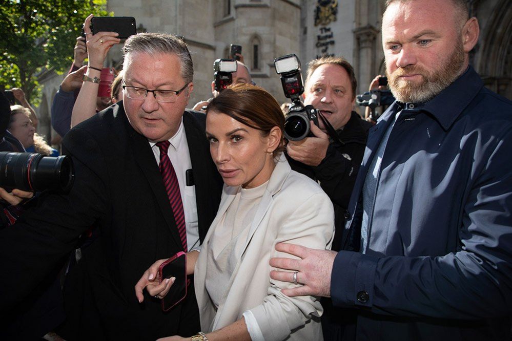Coleen Rooney and Wayne Rooney leave the Royal Courts of Justice surrounded by the press