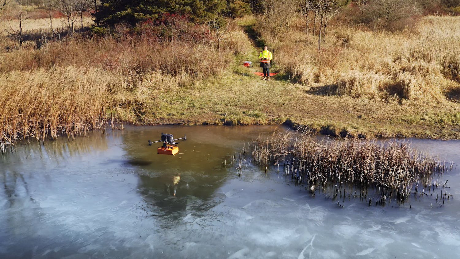 An AltoMaxx drone, equipped with ground penetrating radar, flys over a partially frozen pond to collect data on what's under the surface. - Contributed
