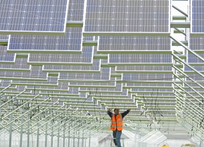 A Chinese worker installs solar panels at a photovoltaic power station in Lianyungang city, Jiangsu Province, China, 15 May 2018 (Photo: Reuters/Oriental Image).