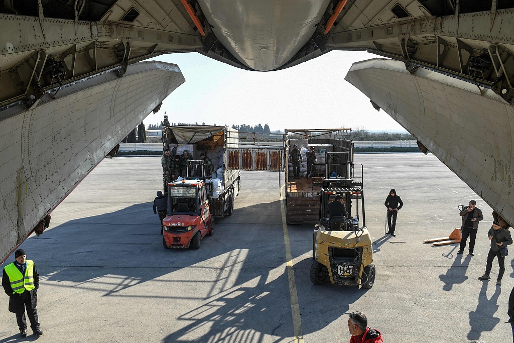 Humanitarian aid relief packages provided by Saudi Arabia for victims of the earthquake in Syria are unloaded off of an Ilyushin Il-76TD transport aircraft at Aleppo International Airport in northern Syria on February 14, 2023.