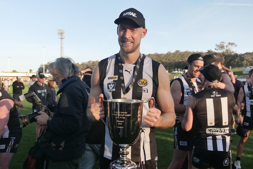 man holding medals around neck