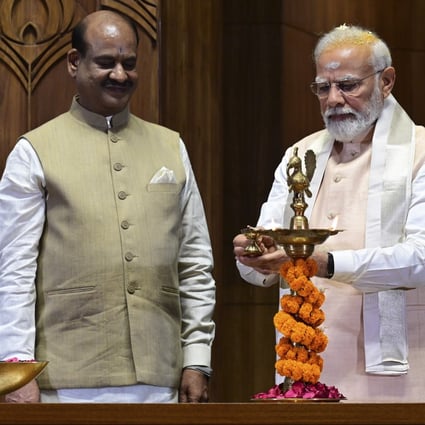 Indian prime minister Narendra Modi lights a lamp after installing a royal golden sceptre near the chair of the speaker, as speaker of the lower house Om Birla watches, during the start of the inaugural ceremony of the new parliament building, in New Delhi, India. Photo: AP