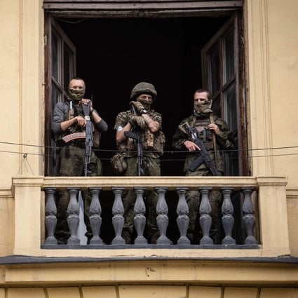 Members of the Wagner group stand on the balcony of the circus building in Rostov-on-Don, Russia, on June 24. Yevgeny Prigozhin, commander of the mercenary group, had ordered his troops to march on Moscow but abruptly reached a deal with the Kremlin to go into exile and sounded the retreat on June 25. Photo: AFP