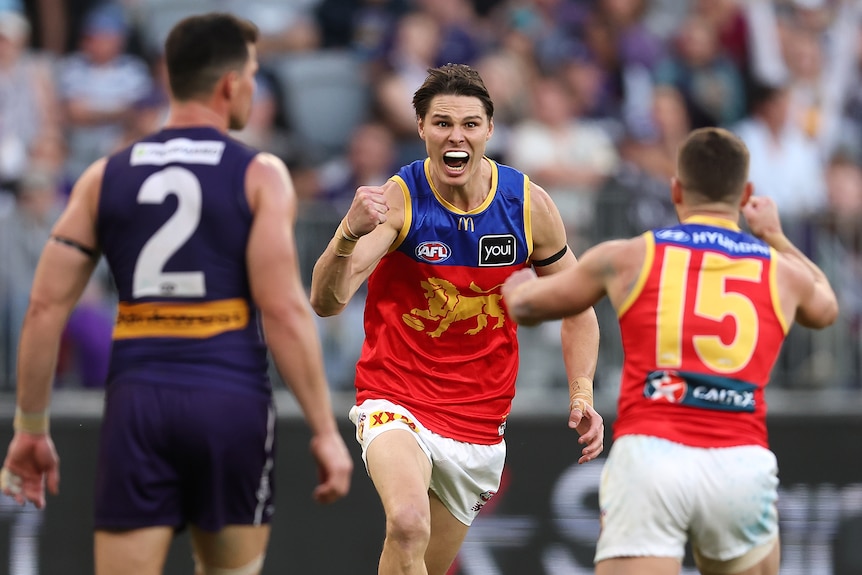 Eric Hipwood clenches his fist and runs towards Dayne Zorko to celebrate