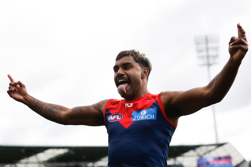 Kysaiah Pickett sticks his tongue out and holds his arms out in celebration