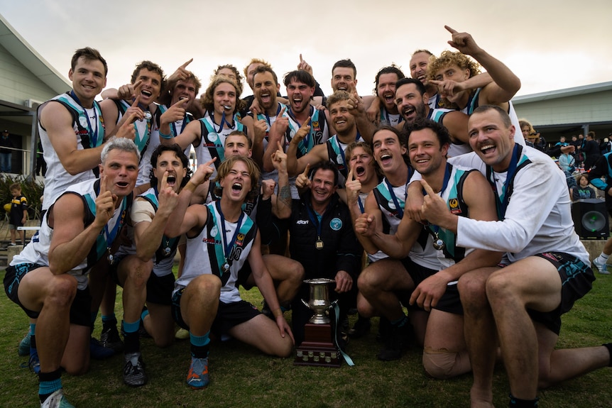 A team of Australian Rules football players pose for a team photo