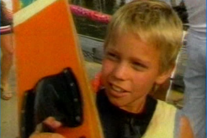 Young boy holding a ski.