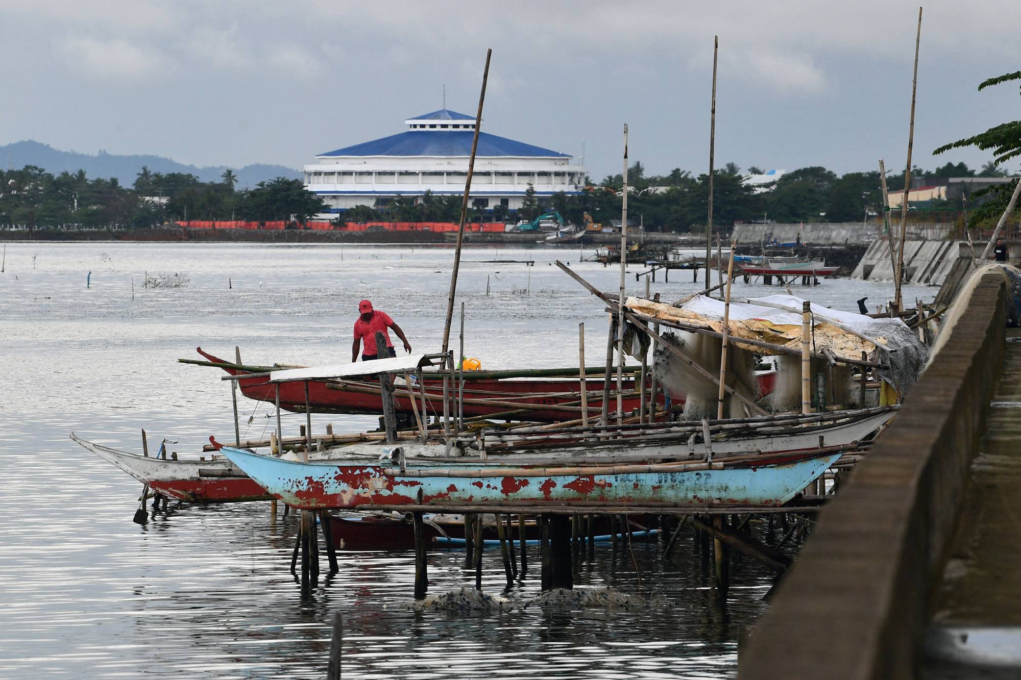 A fisherman stands beside boats by the waterfront where houses once stood before Super Typhoon Haiyan struck in 2013, in Tacloban city, Leyte province. Photo: AFP