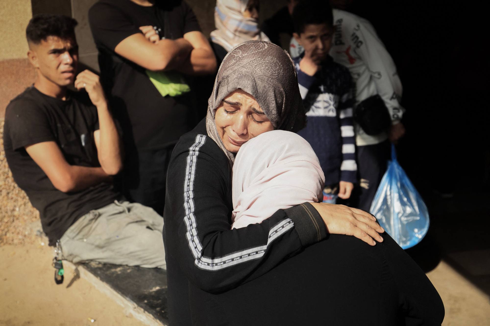 Women comfort each other at Nasser Hospital in Khan Younis, following Israeli air strikes in the southern Gaza Strip city on Monday. AFP