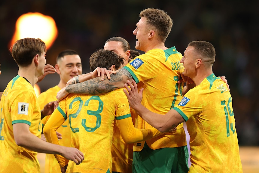 Harry Souttar of the Socceroos celebrates scoring a goal with teammates.