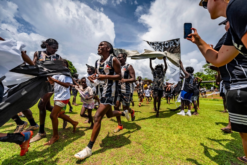 The Muluwurri Magpies run out onto the field.