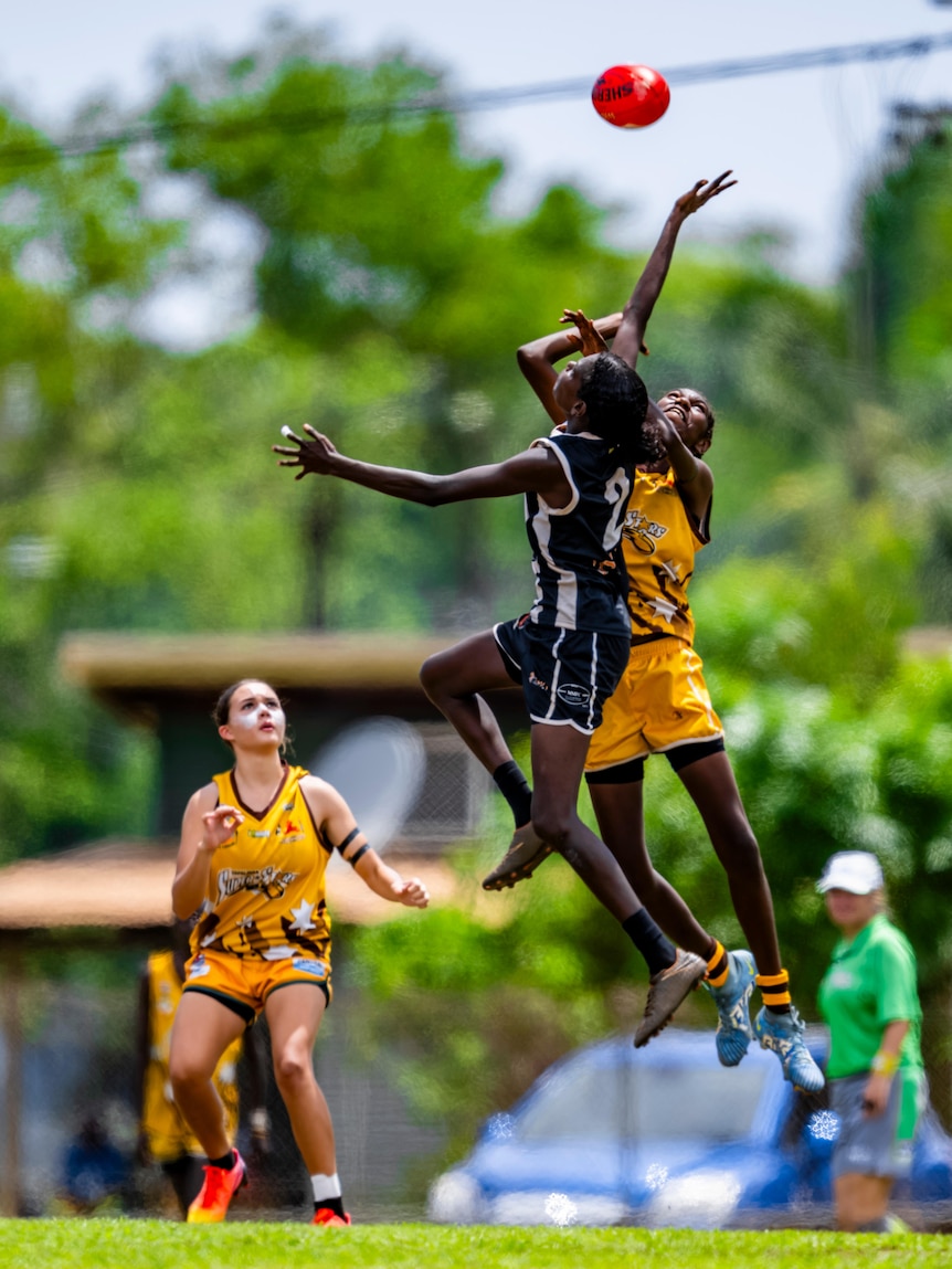 Players fly for the ball in a ruck contest.