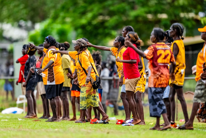 Tapalinga supportes point and yell on the sidelines.