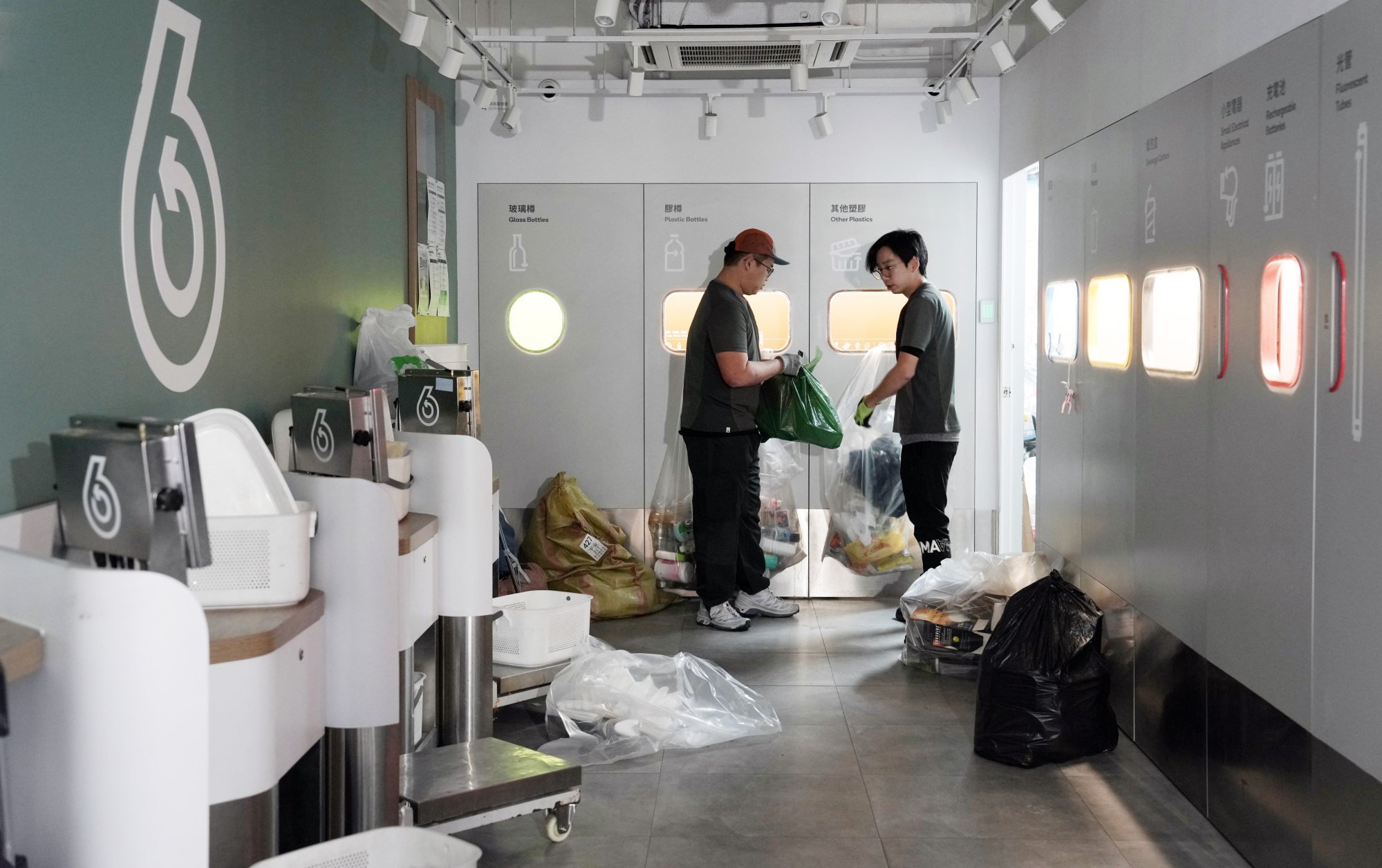 Staff at the Hung Hom recycling centre work to clear the backlog of waste piled up outside its storefront operation over the Christmas break. Photo: Elson LI