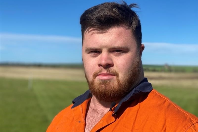 boy stand in paddock wearing orange hi-vis shirt