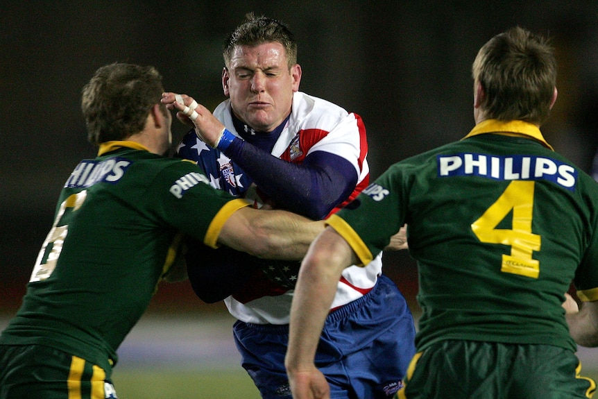 A man runs the ball during a rugby league match
