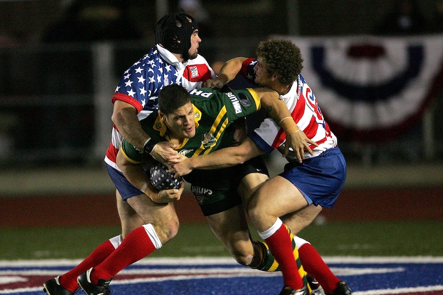 A man runs the ball during a rugby league match