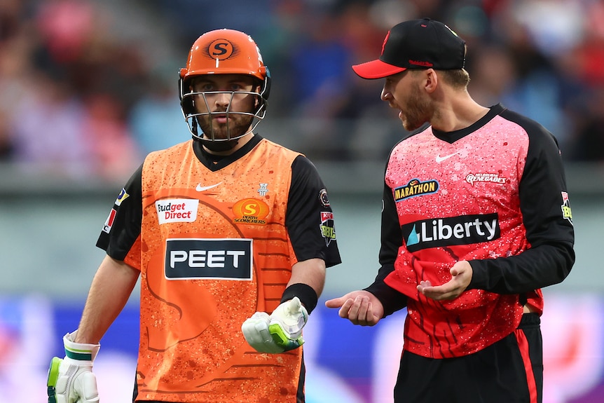 Perth Scorchers batter Josh Inglis speaks to Melbourne Renegades' Joe Clarke as they walk off the field at a Big Bash game.