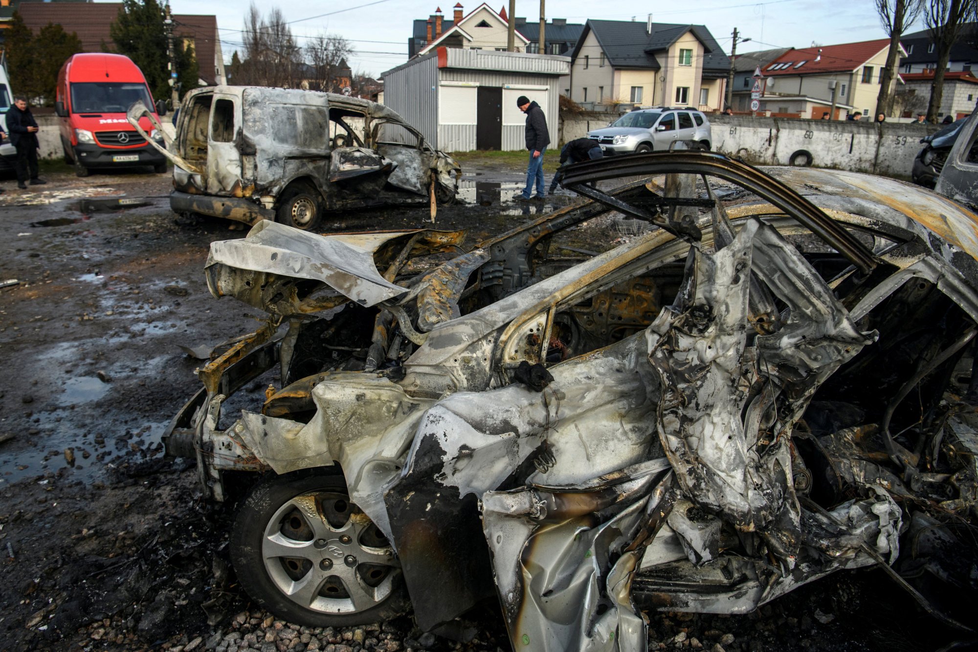 A man walks next to a car destroyed during a Russian missile and drone strike in Kyiv on December 29. Photo: Reuters