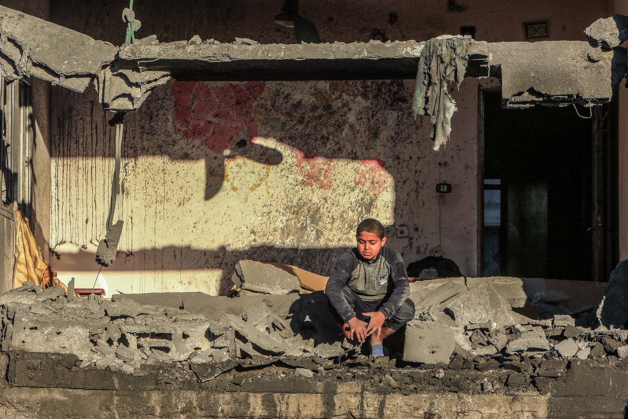 A Palestinian child sits between debris after an Israeli air strike on a house in the city of Rafah in the southern Gaza Strip. Photo: dpa