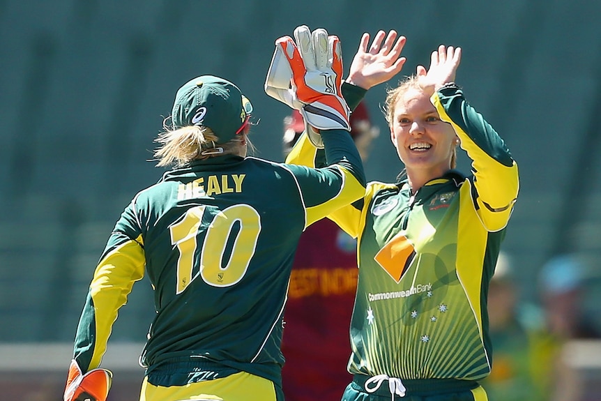 Alyssa Healy and Kristen Beams hi-five after a wicket