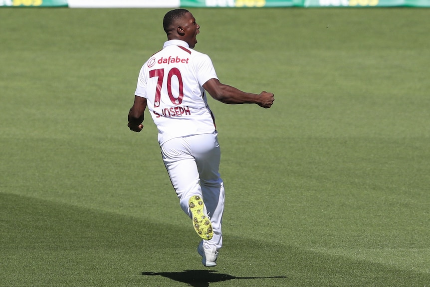 Shamar Joseph runs off with his fists clenched in celebration