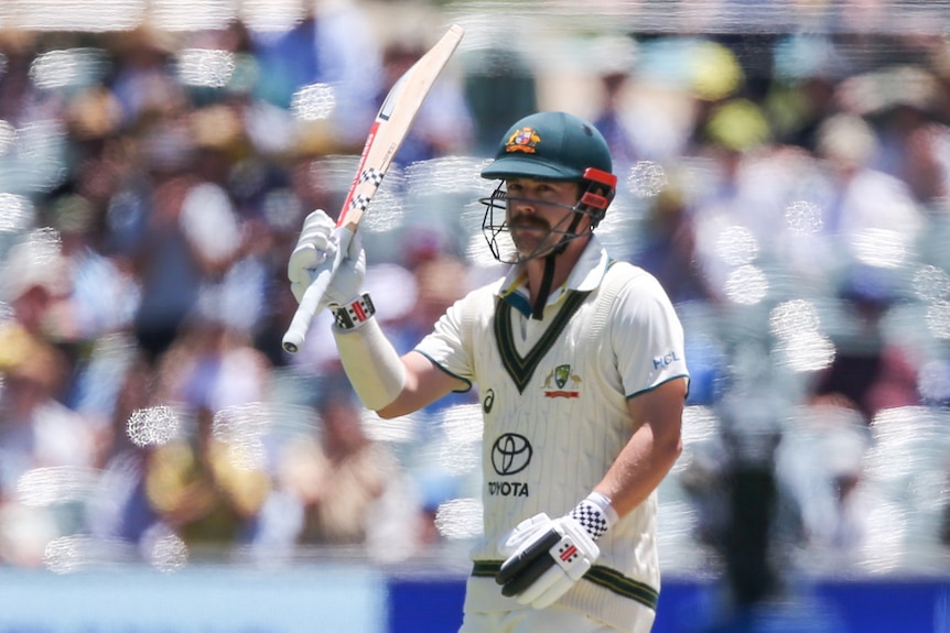 Travis Head holds up his bat