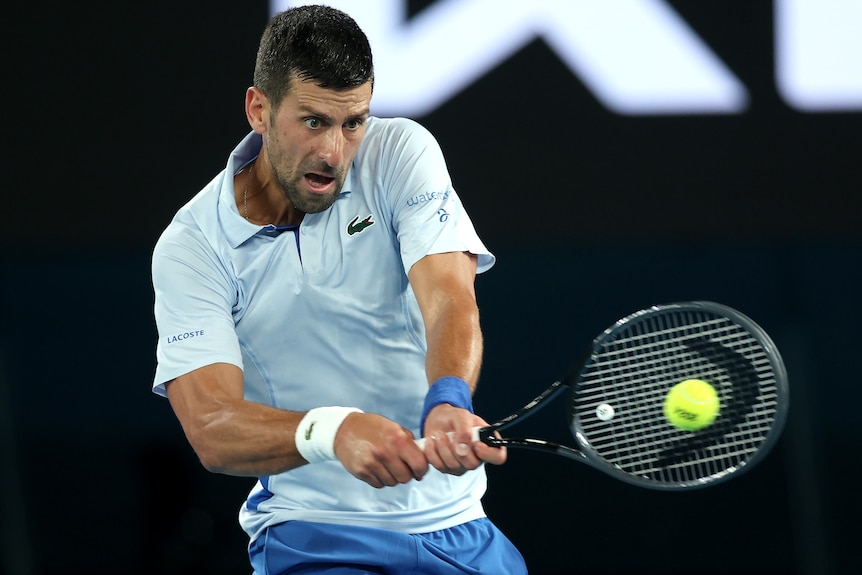 Novak Djokovic plays a backhand at the 2024 Australian Open.