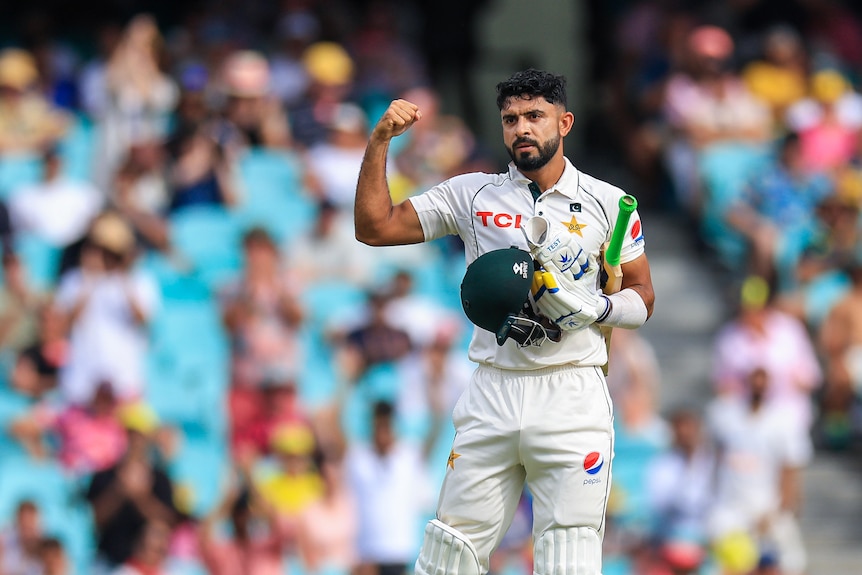 Pakistan batter Aamir Jamal flexes his muscles after a half-century at the SCG.