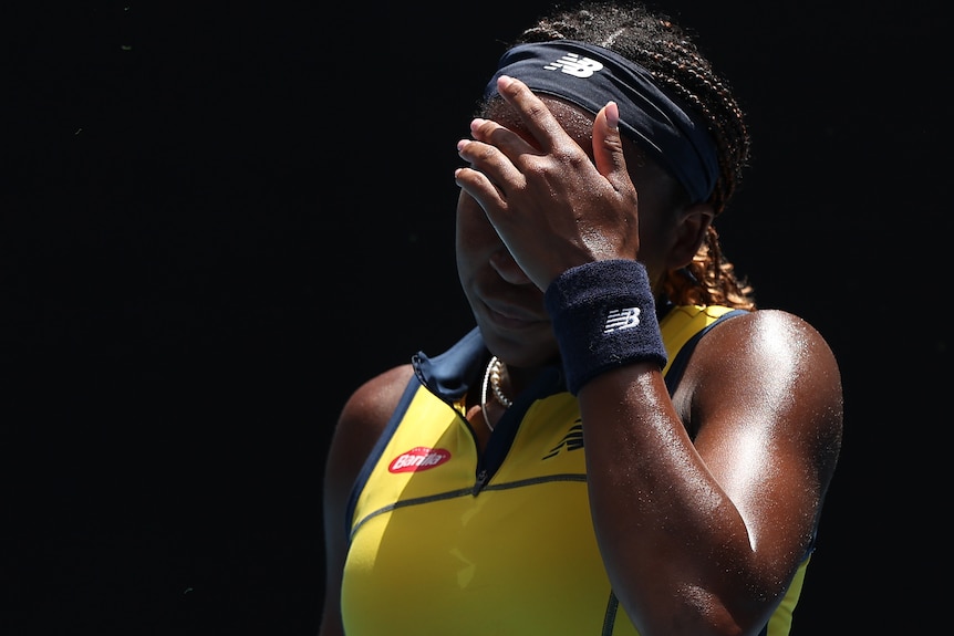 Coco Gauff holds her left hand on her face during a 2024 Australian Open match.