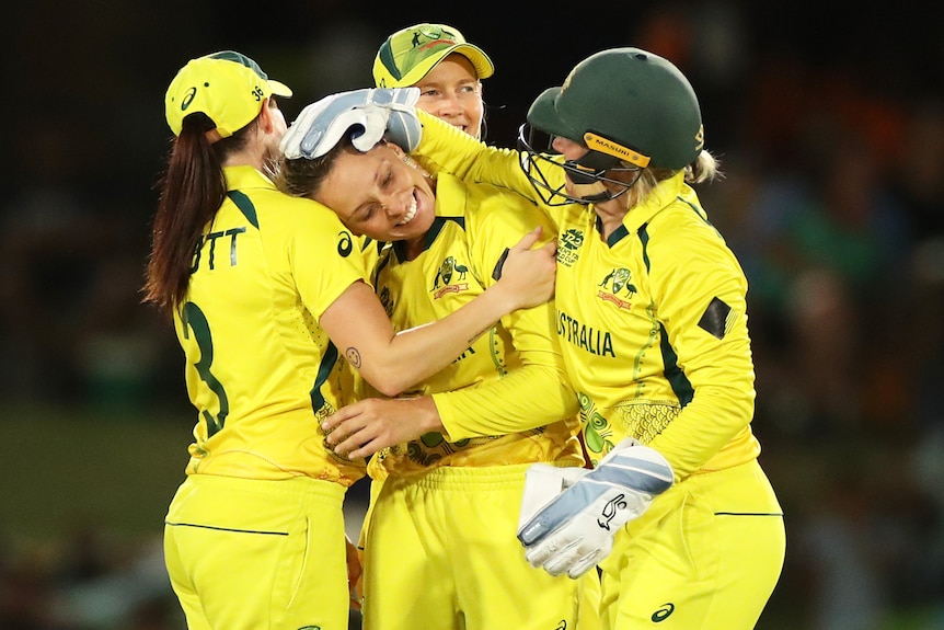Four Australian players embrace as they celebrate a wicket at the ICC Women's T20 World Cup.