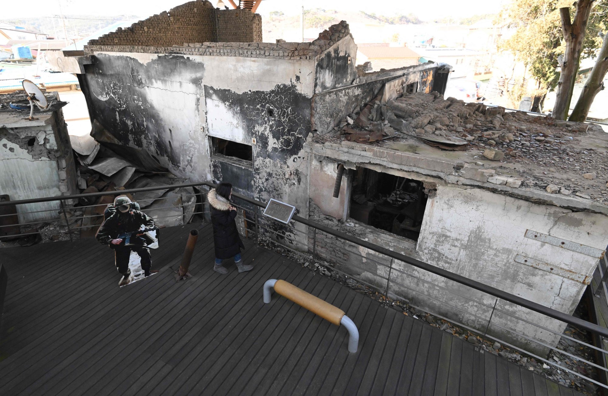 A woman looks at wrecked homes hit by North Korea’s 2010 shelling attack at a museum that displays materials related to the attack on Yeonpyeong island on Saturday. Photo: AFP