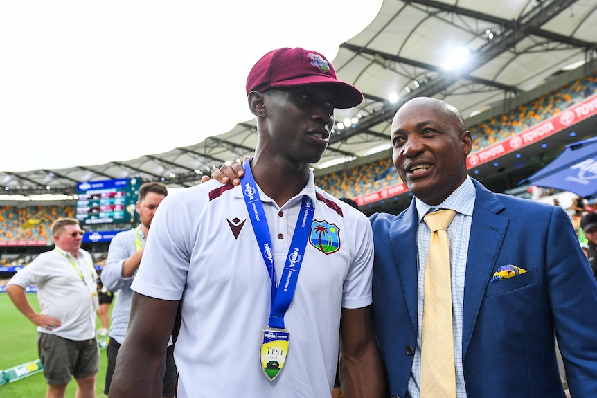 Shamar Joseph and Brian Lara walk next to each other