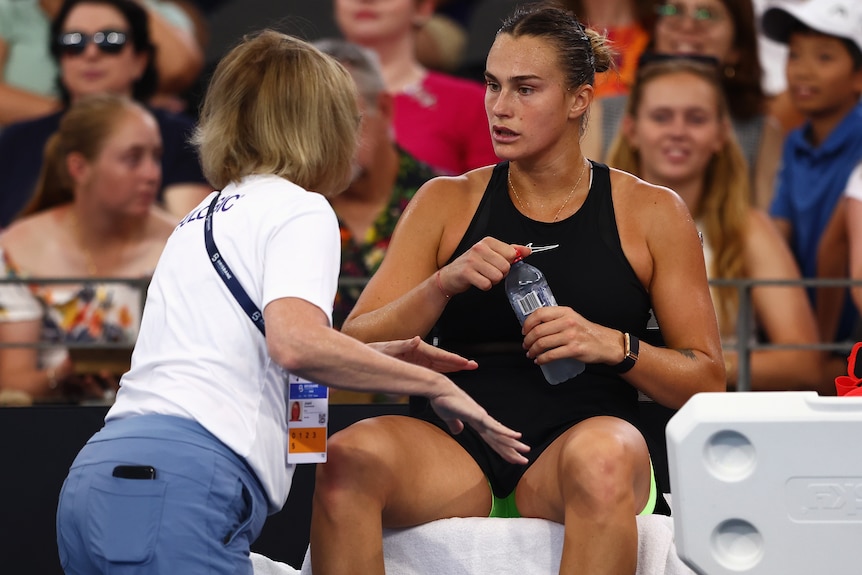 Aryna Sabalenka talks to a physiotherapist.