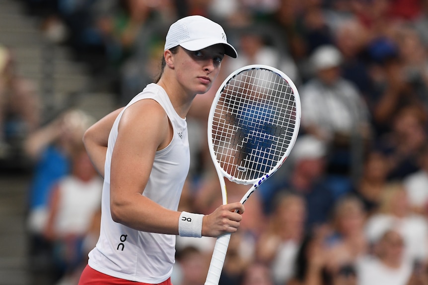Iga Świątek holding a tennis racquet. 
