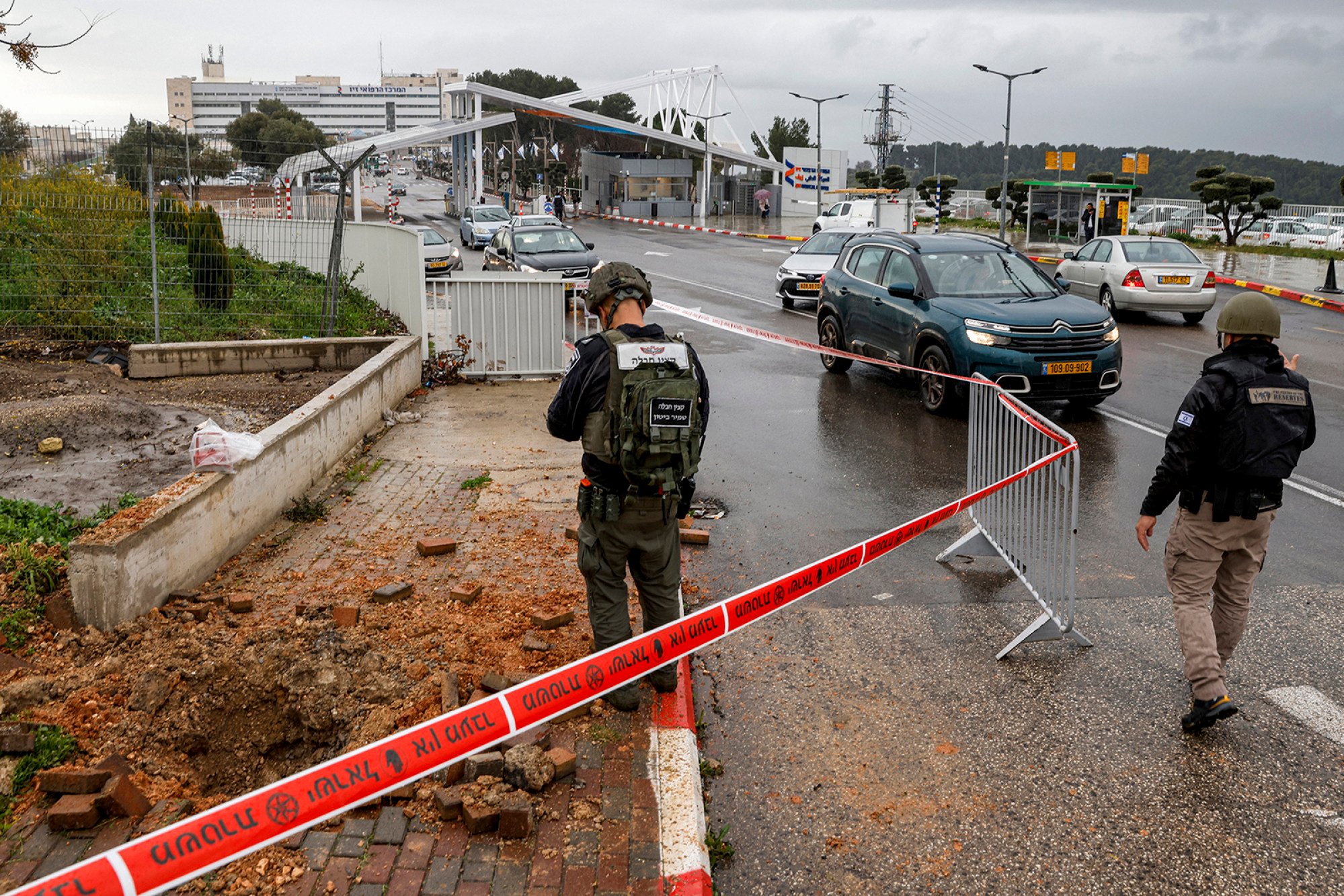 An Israeli policeman inspects the impact crater left by a rocket fired from southern Lebanon that landed near the entrance of Ziv hospital in Israel’s northern city of Safed on Wednesday. Photo: AFP/TNS