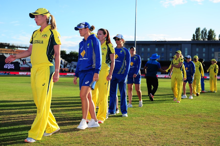 Australia look crestfallen as they form a line and prepare to shake India's hands