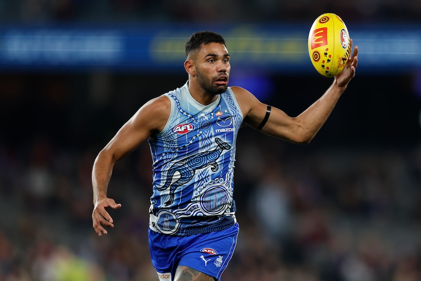 An AFL player looks to move the ball