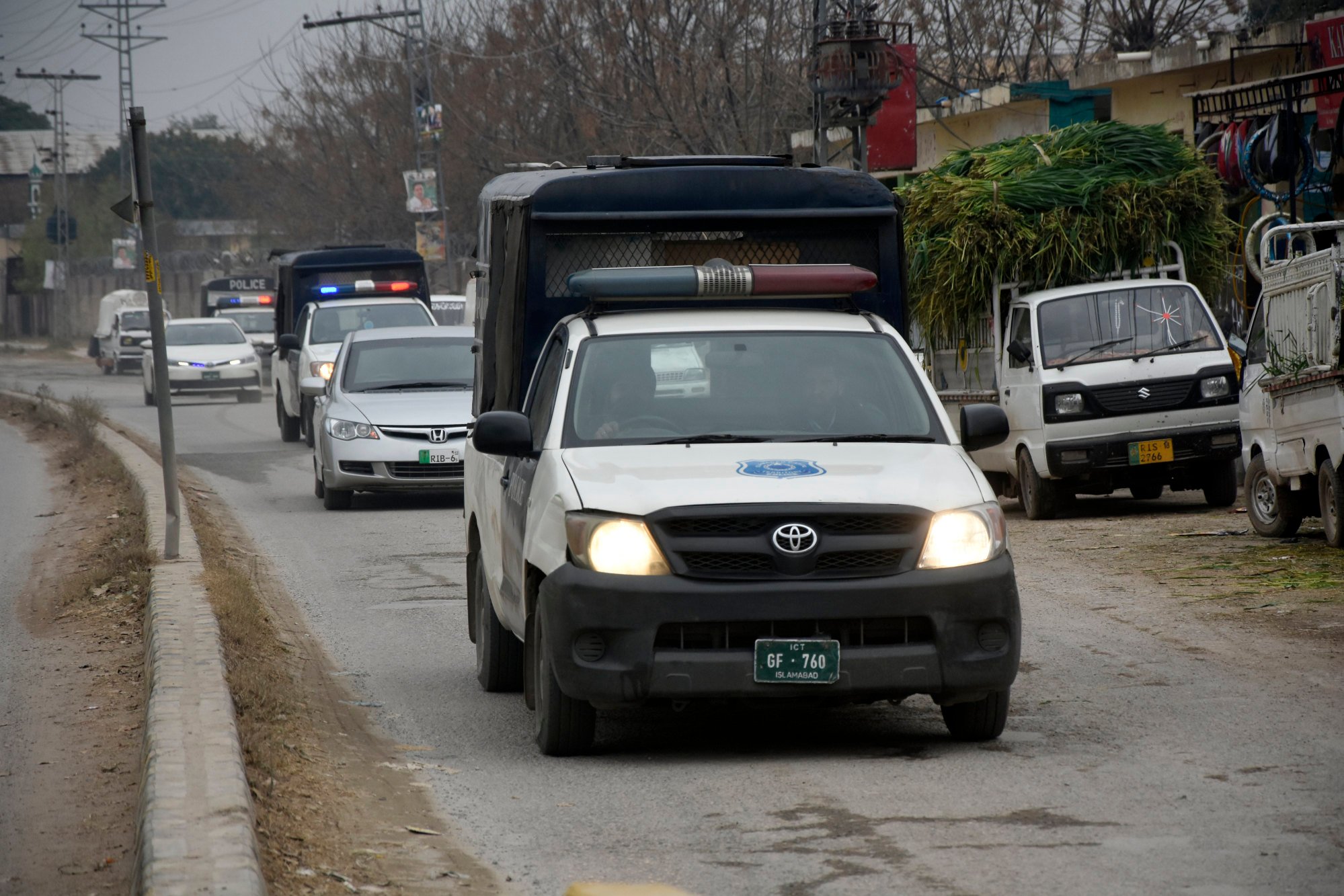 Police officers escort a car carrying Imran Khan’s wife Bushra Bibi to a court in Rawalpindi, Pakistan, on Saturday. Photo: AP