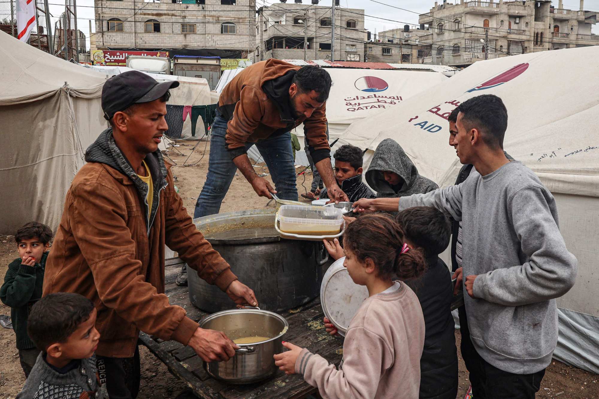 Volunteers distribute rations of red lentil soup to displaced Palestinians in Rafah in the southern Gaza Strip on February 18. Photo: AFP