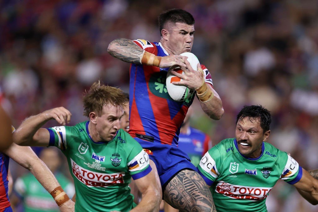 Bradman Best jumps above Raiders players to catch a ball during an NRL game.