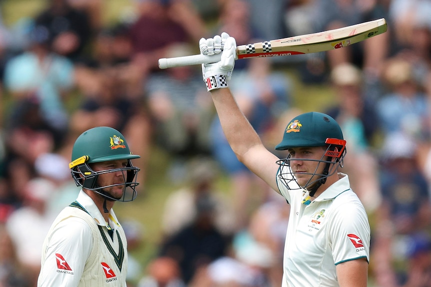 Cameron Green raises his bat next to Josh Hazlewood