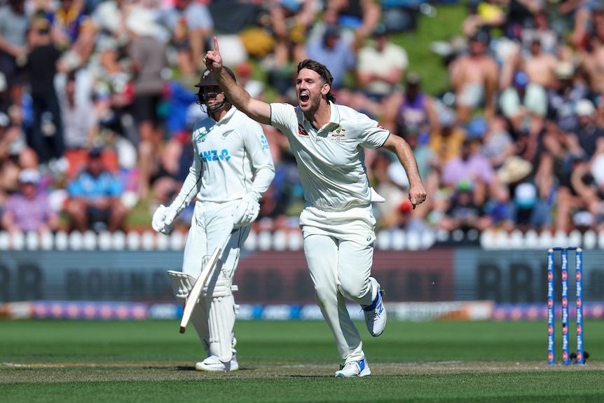 Mitch Marsh holds his finger up and runs through after a wicket