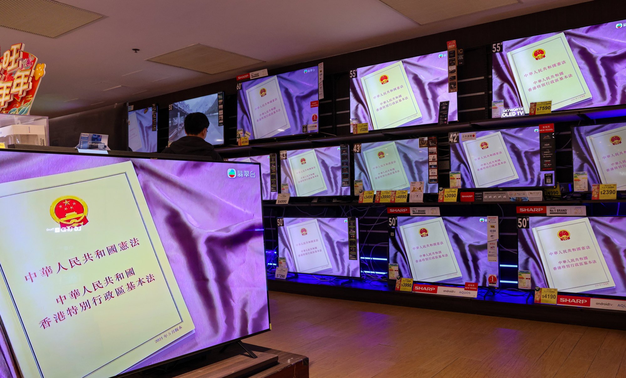 A press conference about Article 23 legislation is seen on a bank of television screens. The legislation is required by Hong Kong’s mini-constitution, the Basic Law. Photo: Jelly Tse